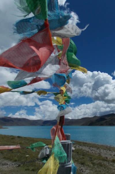 Blick auf See mit Gebetsfahnen in Tibet