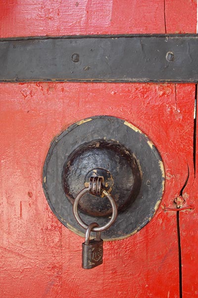close-up eines Türgriffs on roter Tür in Tibet